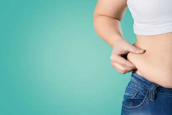 Image of woman pinching her love handles to show weight gain Hampton in Arden